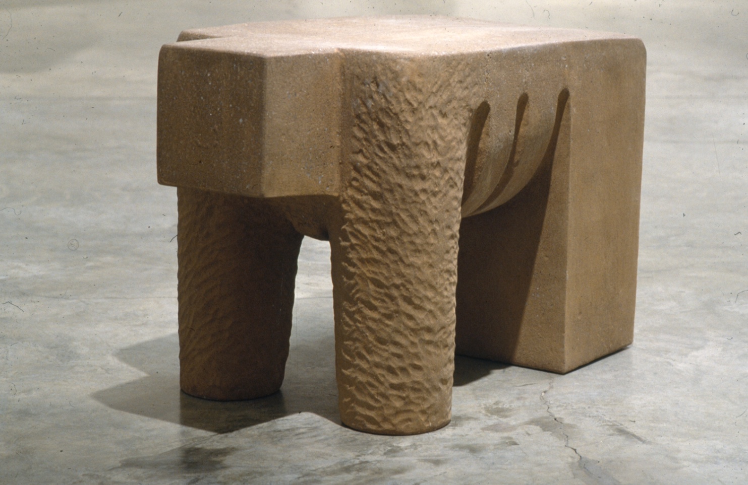 A concrete elephant shaped table with two legs.
