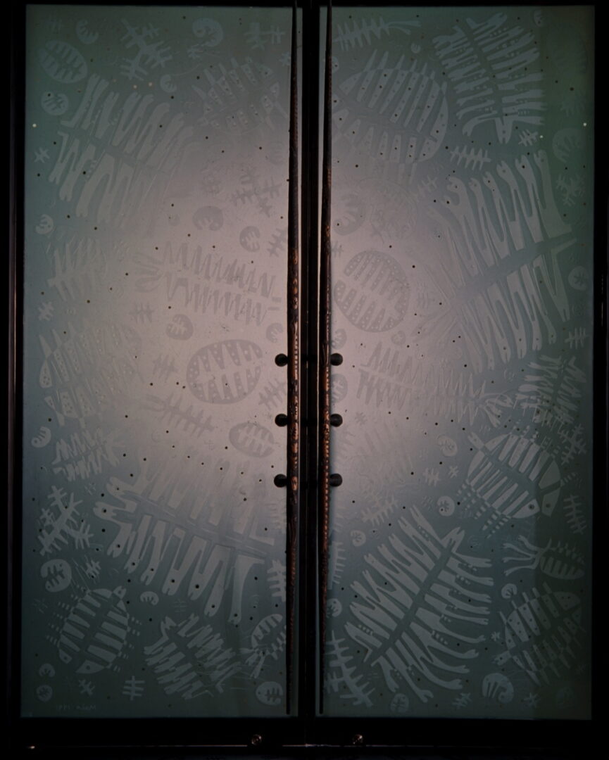 A close up of two doors with a plant design on them