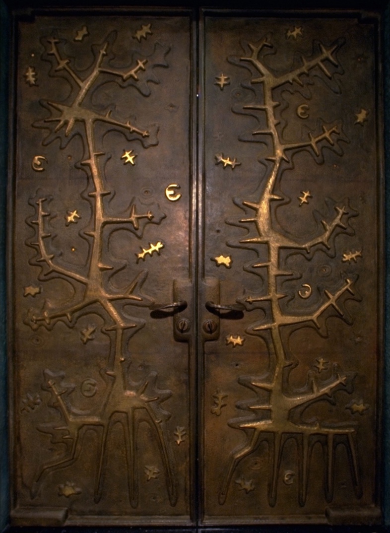 A pair of doors with trees and leaves on them.