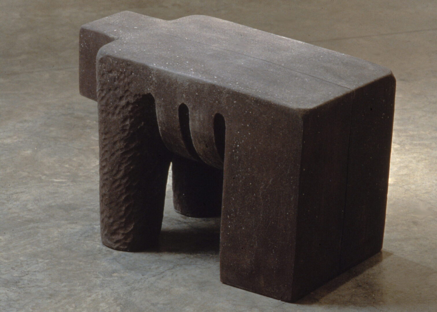 A concrete bench sitting on top of the ground.