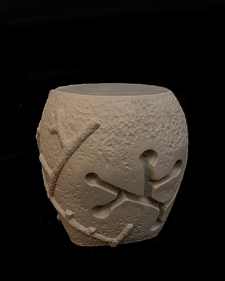 A white vase with some shapes on it
