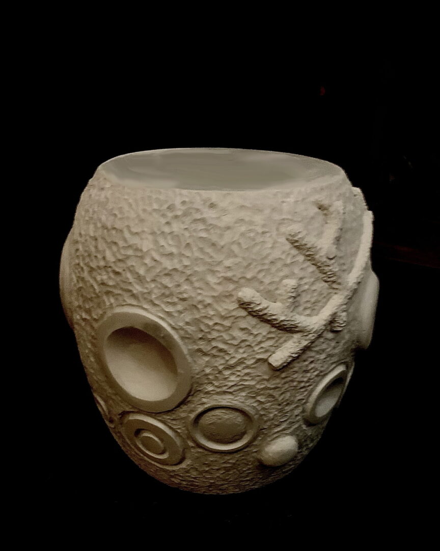 A white vase with some shapes on it