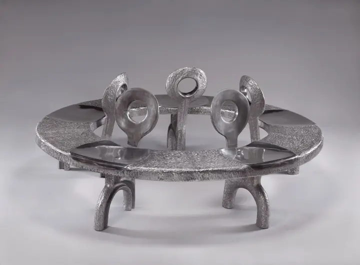 A silver tray with a metal sculpture on top of it.