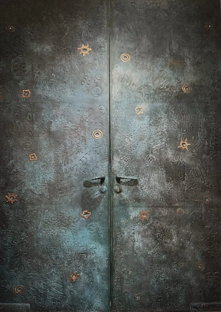 A close up of two doors with some metal designs