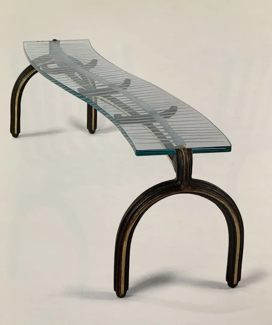 A glass table with metal legs on top of it.