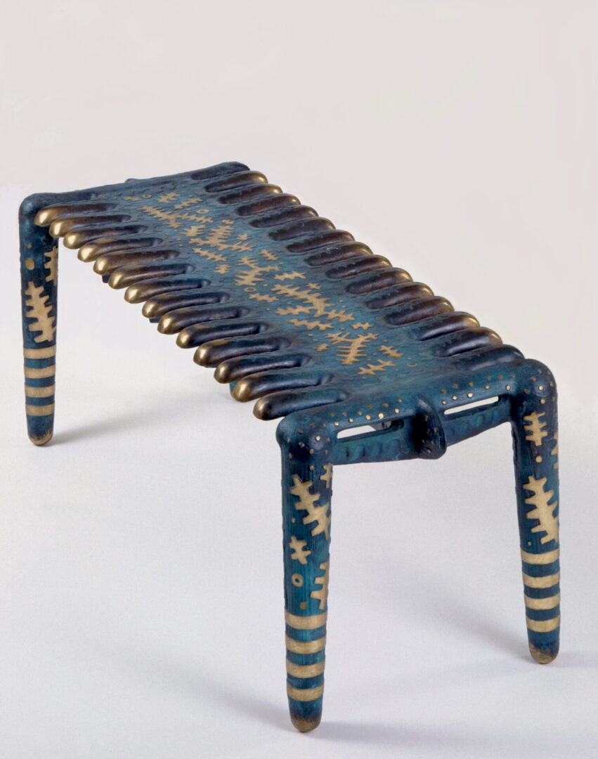 A blue bench with gold and black designs on it.